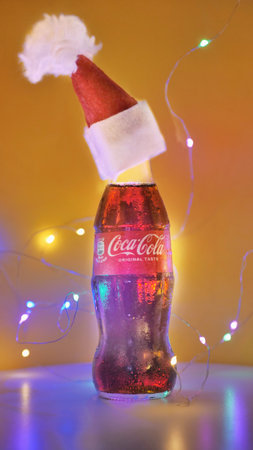 Rome Italy. September - 06. 2020. glass can of Coca-Cola in a Christmas hat on a yellow backgroundのeditorial素材