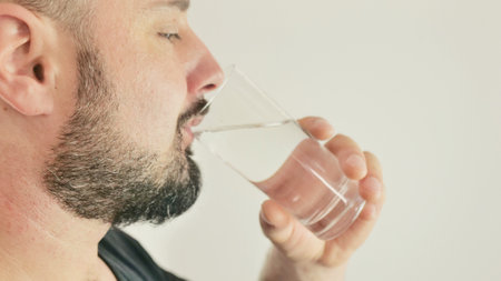 A young man drinks water from a glassの写真素材