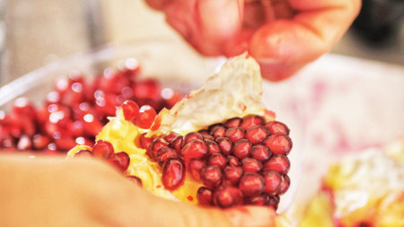 Womens hands clean fruit pomegranateの写真素材