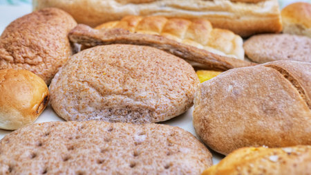 Bread and Bakery Products Isolated on White. Different types of bread: sesame bun, baguette, baked...