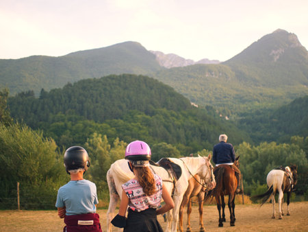 Children learn to ride horses by the river until sunset.の写真素材