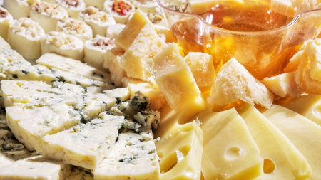 plate of snacks with assorted cheese and honey dish. View from above.の写真素材