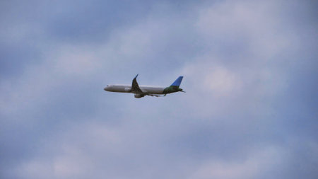 White passenger airplane flying in the sky amazing clouds in the background - Travel by air...