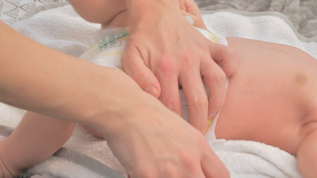 Mother changing her babys diaper on table, closeupの写真素材