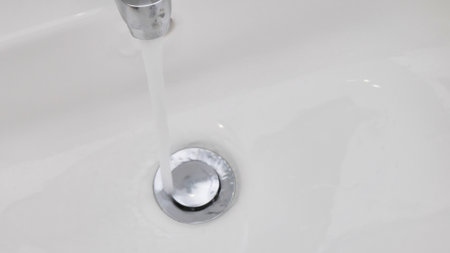 A jet of water flows into the sink, the concept of waste water and environmental problems