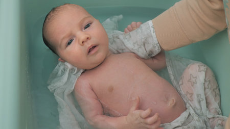 mother bathing a newborn baby. little boy taking bath, baby care