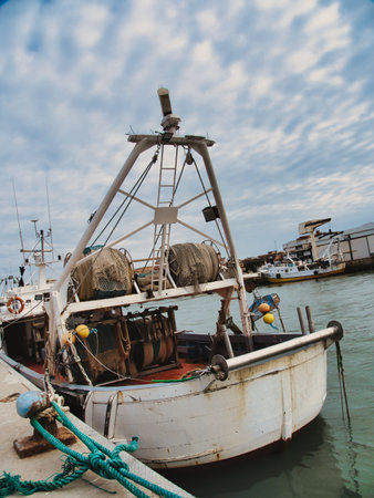 View of the industrial harbor: an old rusty fishing boat moored at the docks,の写真素材