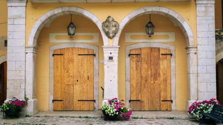 Beautiful entrance of ancient wooden doors and flower near it.の写真素材
