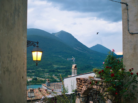 a view from the window to a mountain town, a panorama of mountains, a lantern and tenement houses. A sunny day in an old mountain village built on top of a mountain.の写真素材