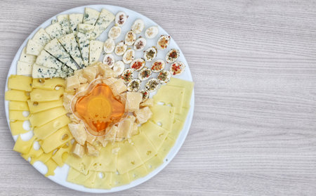 plate of snacks with assorted cheese and honey dish. View from above.の写真素材