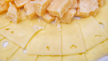 plate of snacks with assorted cheese and honey dish. View from above.