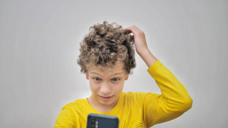teenager squeezes pimples while looking at phone. The problem of teenage acne.の写真素材