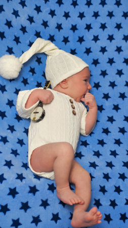 Newborn baby boy wearing knitted pants and hat sleeping on his tummy. Infant child kid napping and holding hand under cheekの写真素材