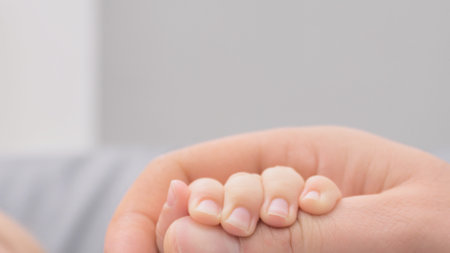 parents hands holding newborn babys fingers close up of fathers hand holding their newborn baby. Love family day, healthcare and medical part of the body fathers day conceptの写真素材