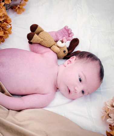 a newborn baby is lying on a white fur in a capの写真素材