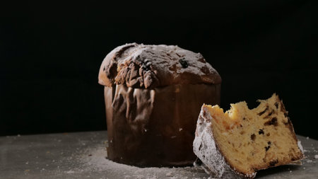 Panettone with dried fruits on black background, selective focus.
