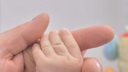 parent's hands holding newborn baby's fingers close up of father's hand holding their newborn baby. Love family day, healthcare and medical part of the body father's day concept.の写真素材
