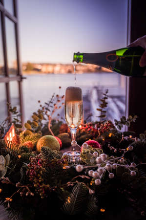Pouring champagne into the glass by the lakeのeditorial素材