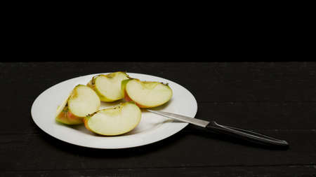 Cut Apple on a black background on a Table with Knifeの写真素材