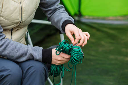 female hand holding rope skein, close-up. accessories and equipment for for camping and outdoor...