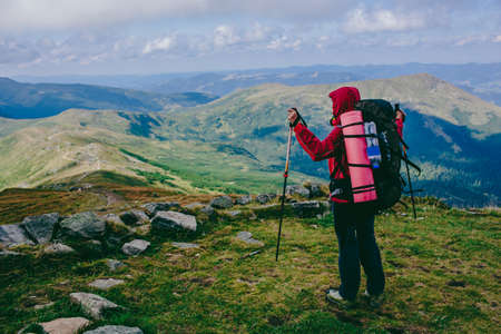 woman traveler standing on the background of a mountainous area. Hiking in the mountains