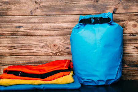 Swimming waterproof bag and clothes on wooden backgroundの写真素材