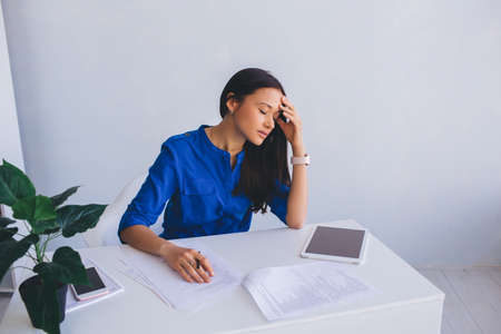 attractive young woman feeling tired, leaning her head on hand and closed eyes. Failure and Fatigue of office workの写真素材