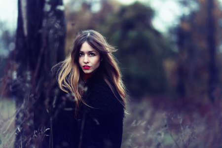 young fashionable woman in colourful autumn forestの写真素材