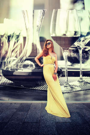 yellow dress young woman staying before the wallの写真素材