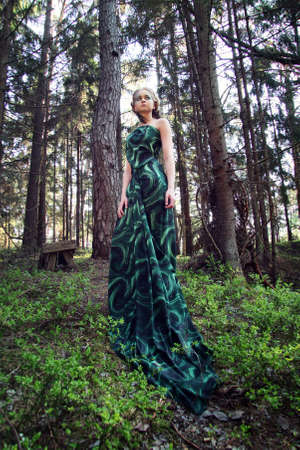 wild beauty blonde woman long green dress in the forestの写真素材