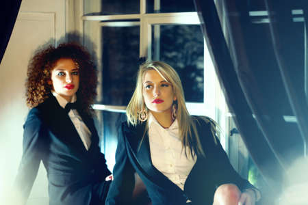 two luxury sexy women on the window desk night look suitの写真素材
