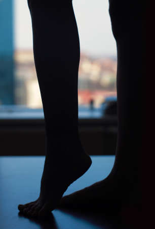 nude business woman feet legs silhouette on table in officeの写真素材
