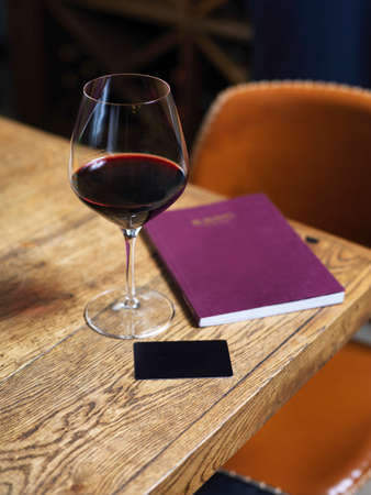 glass of red wine with wine card on the wooden tableの写真素材
