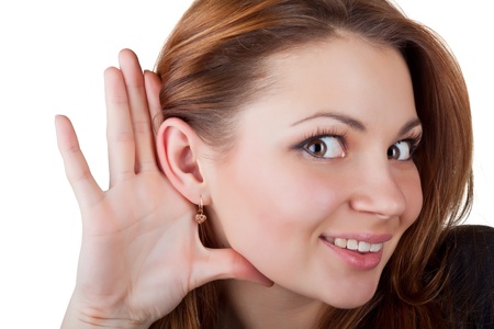 Woman with hand to ear listening, isolated on white backgroundの写真素材