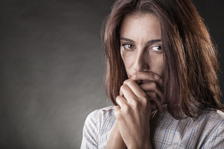 Young crying woman on a dark backgroundの写真素材