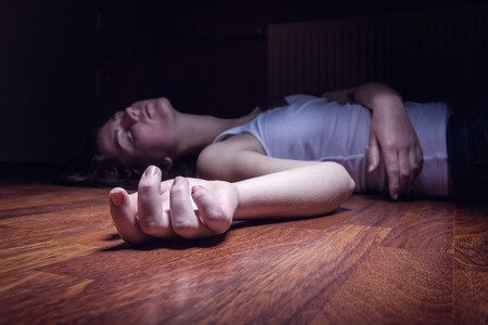 The dead woman's body. Focus on hand