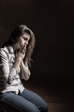 Sad woman sitting alone in a empty roomの写真素材