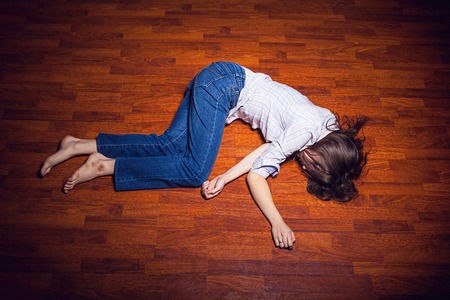 Girl lying on the floor in an empty roomの写真素材