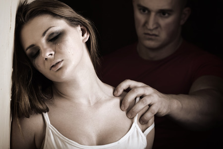 Crying woman with menacing manの写真素材