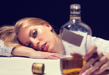 Young beautiful woman in depression, drinking alcoholの写真素材