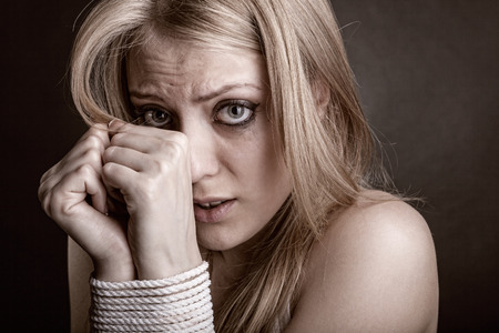 The woman victim of domestic violence and abuse against a dark background