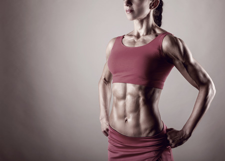 The body of a young athletic girl on gray backgroundの写真素材
