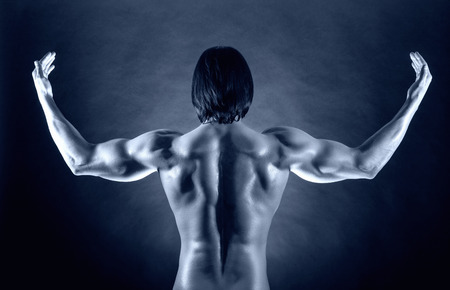 Athletic man shows his muscular backの写真素材