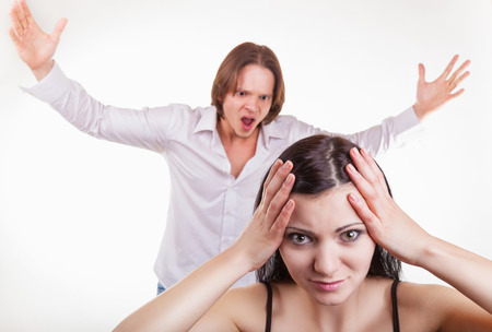 Furious, the husband yells at his wife, on a white background. Focus on girlの写真素材