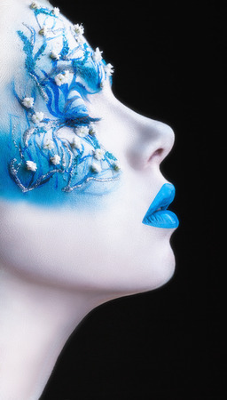 Beautiful woman with fashion make-up. White skin with blue shadows and lips on a black の写真素材