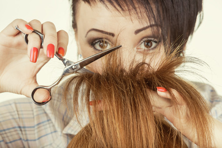 Young woman hairdresser at work. Close-up of haircut hair tipsの写真素材