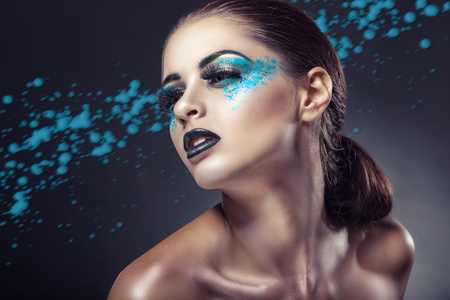 Close-up of a young woman with fashion makeup on a dark backgroundの写真素材
