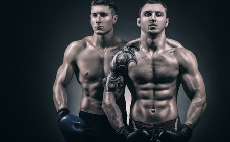 Two young boxer with boxing gloves before a fight on a black backgroundの写真素材