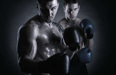 Two young boxer with boxing gloves before a fight on a black backgroundの写真素材