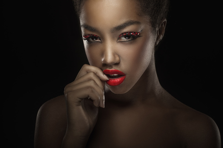 Close-up of a beautiful black woman with fashion make-up, red lips. Glamorous portraitの写真素材